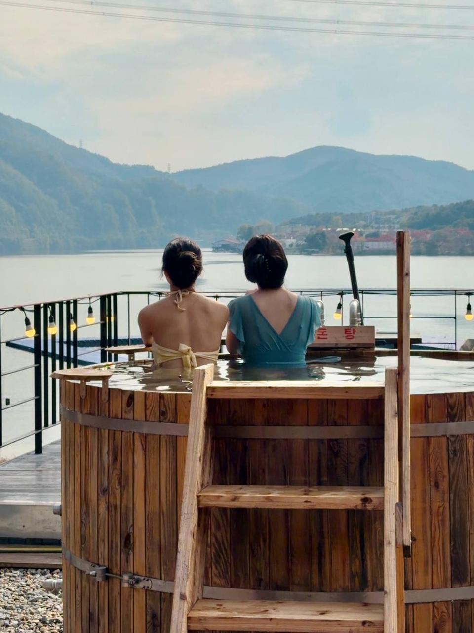 两人在湖景前体验户外木桶热汤